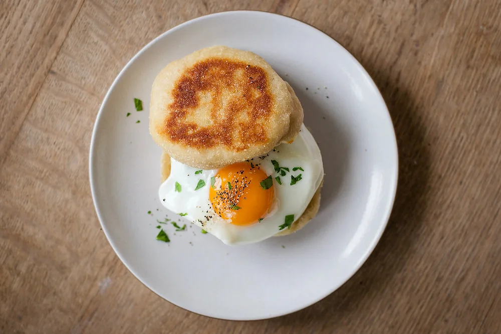 Breakfast sandwich with sausage and cheddar on English muffin